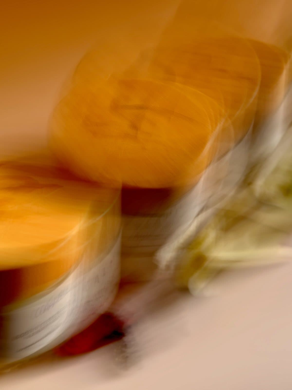 Scented Shea jars in motion against a warm amber ground
